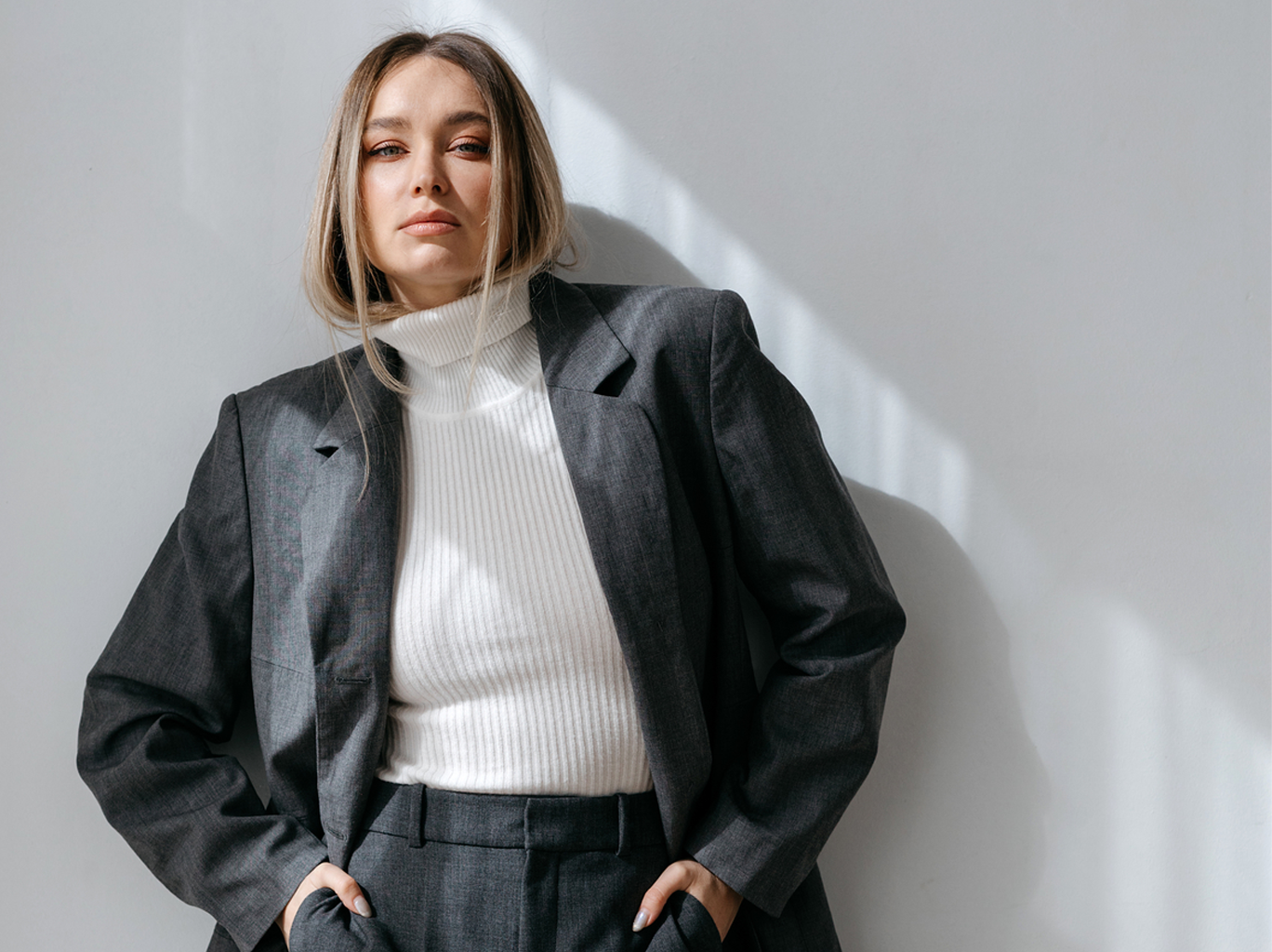 Woman standing against a wall trying to overcome imposter syndrome