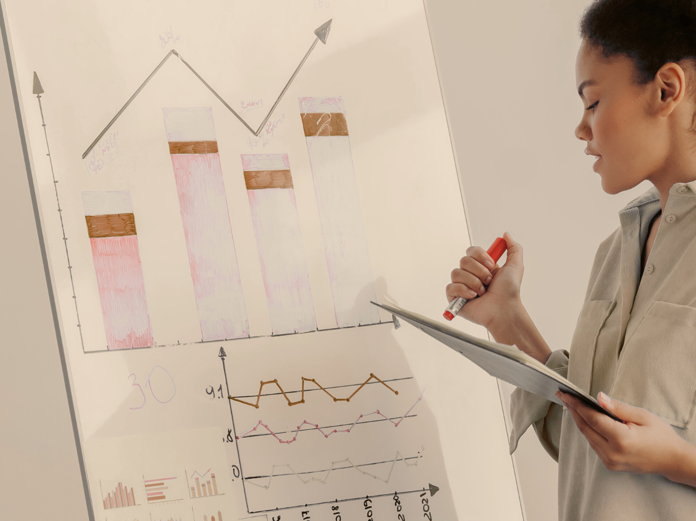 lady holding a pen working on charts and graphs